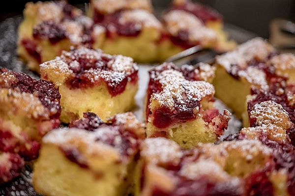 Kuchenstücke mit Früchten und Puderzucker